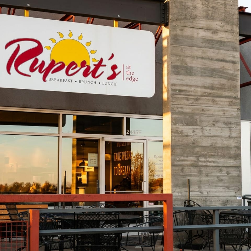 Rupert's at the Edge restaurant exterior with sign, large windows, and outdoor patio seating.